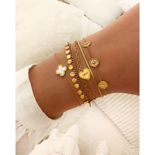 Model draagt gouden armbanden mix