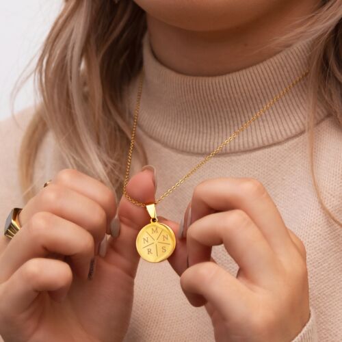 Model draagt gouden ketting met initialen