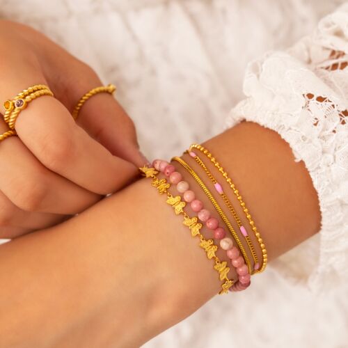 Vlinder armband gecombineerd met andere gouden armbanden