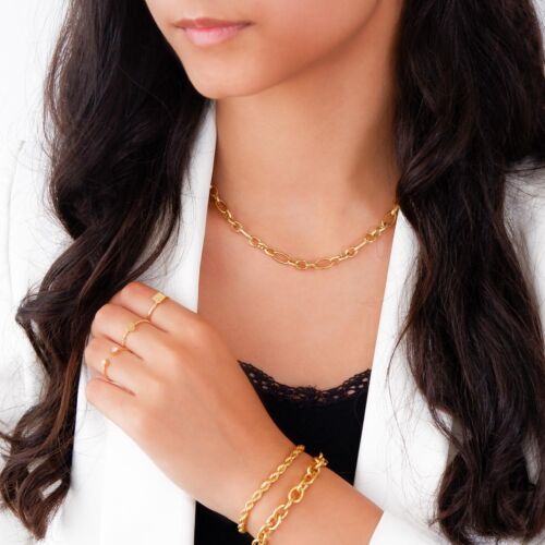 Trendy gouden schakelketting bij een witte blazer