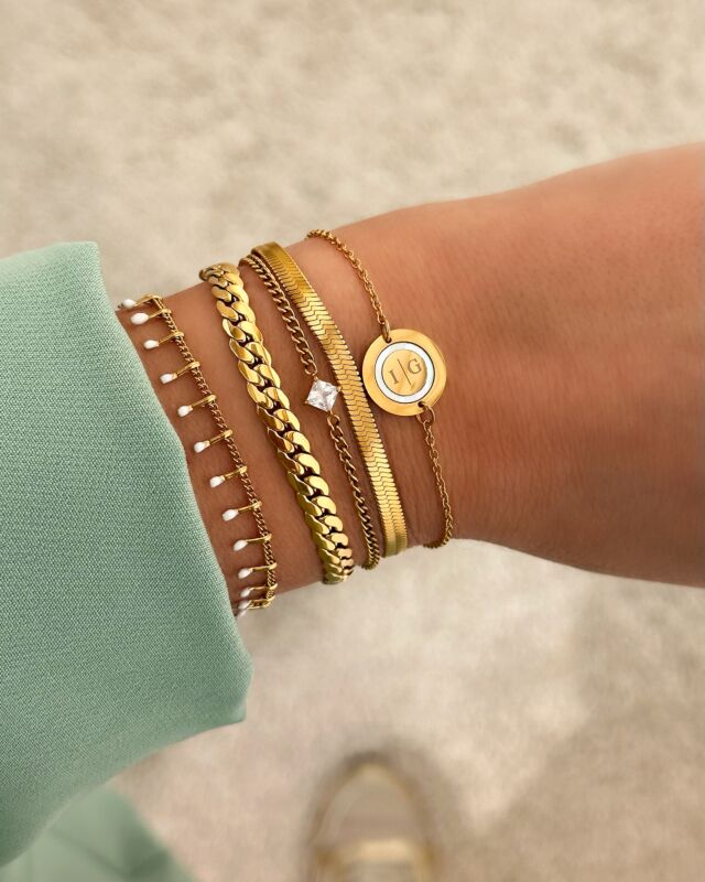 5 gouden armbandjes om pols