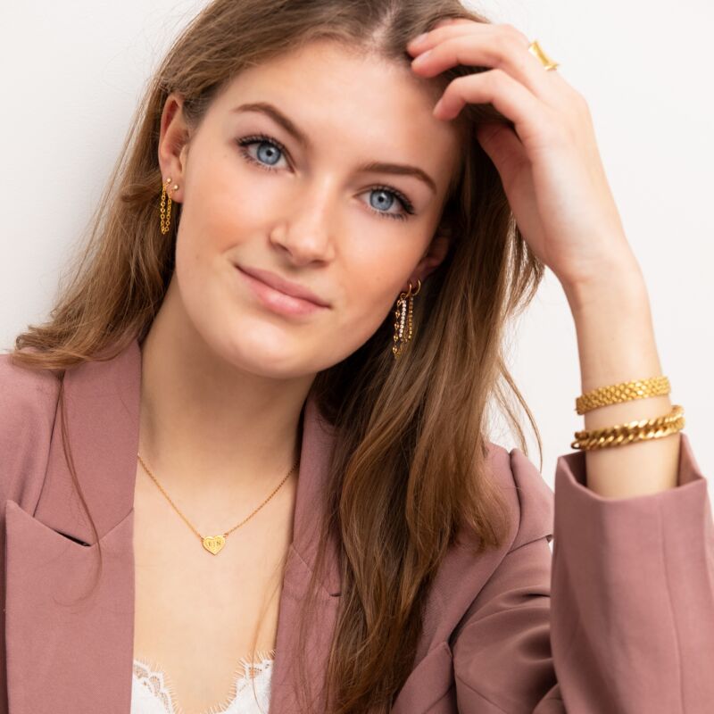 gouden sieraden om vrouw met roze blazer