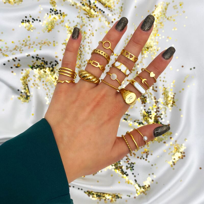 mix van gouden ringen om vinger vrouw met glitter achtergrond