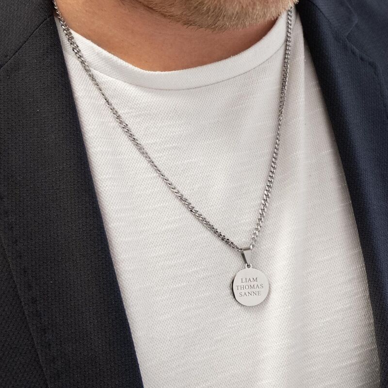 Man met graveerbare ketting met zilveren munt