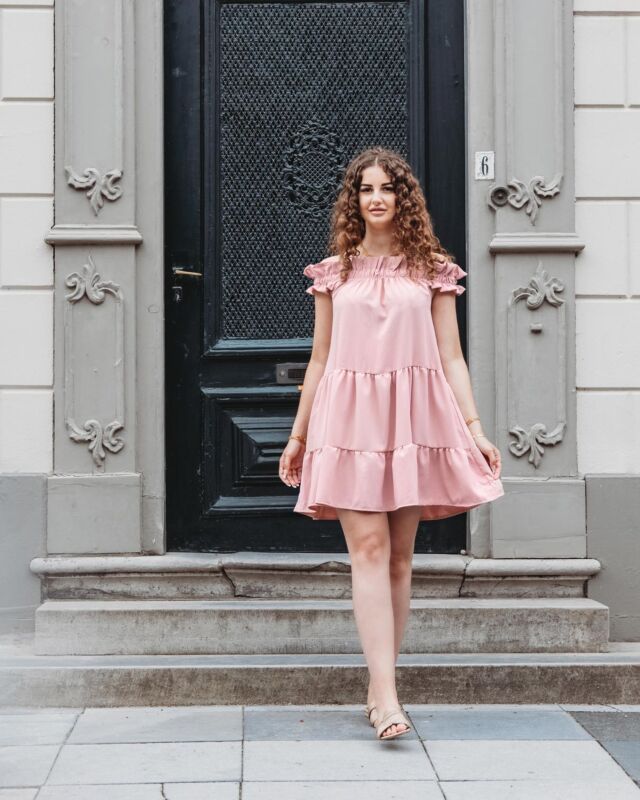 Off-shoulder jurk in het roze gedragen door model