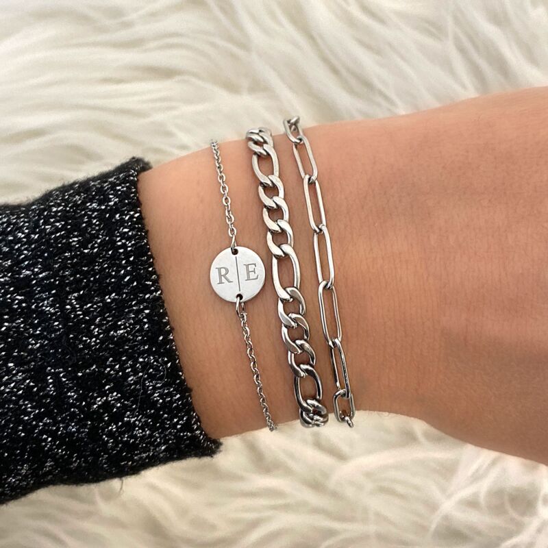 Zilveren armparty met twee initialen en een minimalistische schakelarmband