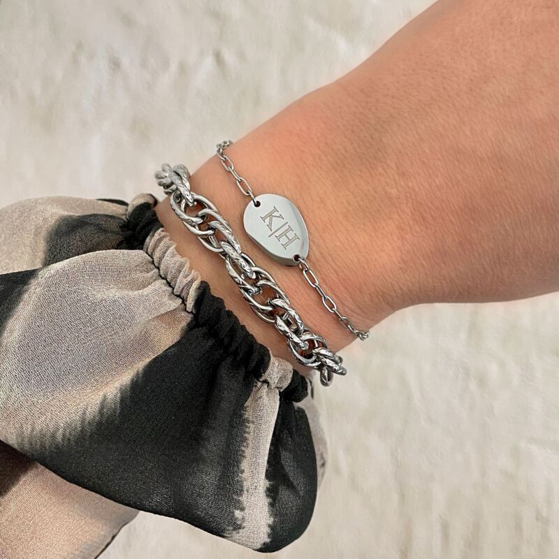 Vrouw draagt graveerbare charm armband om pols