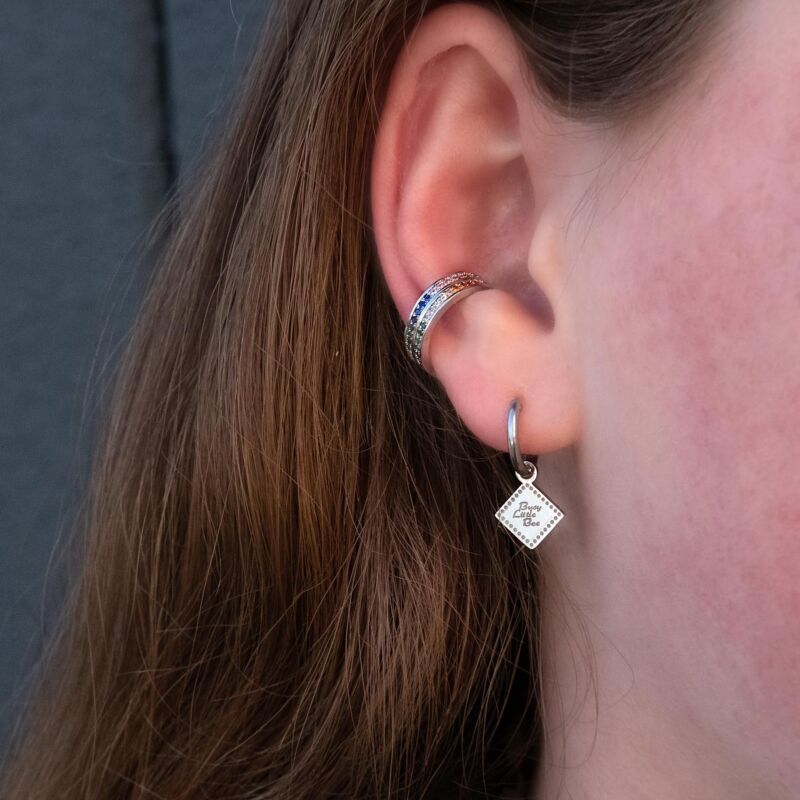 vrouw draagt regenboog ear cuff in het oor