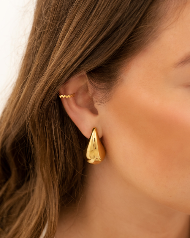 Model draagt gouden ear cuff zigzag
