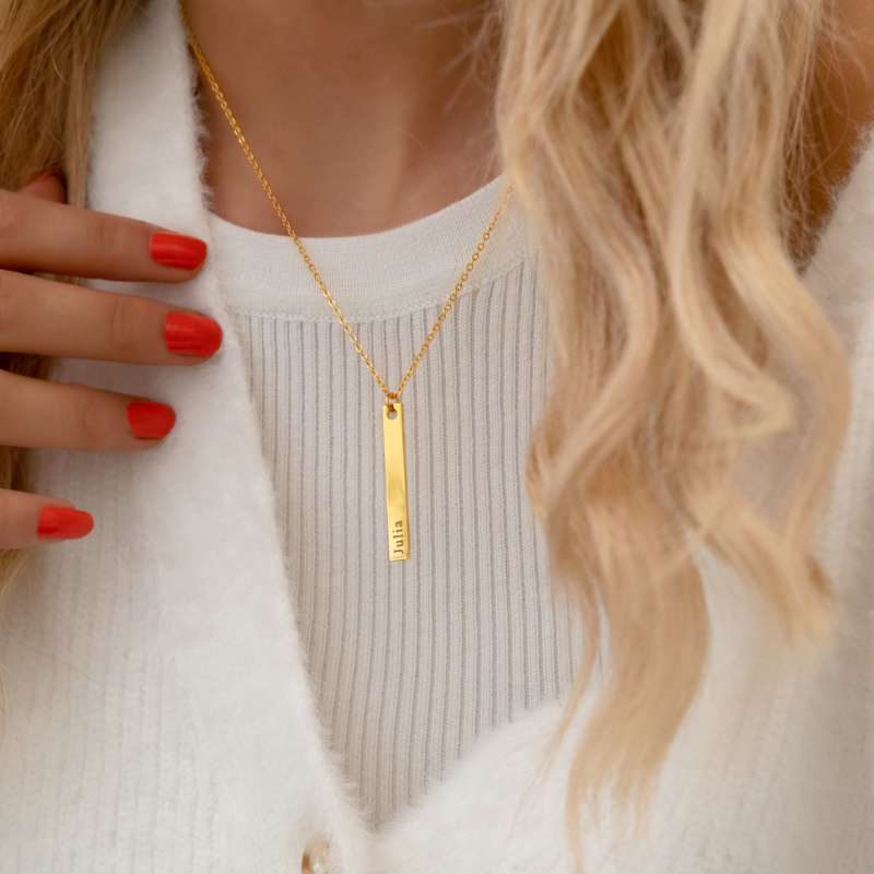 gouden ketting graveerbaar met staaf om nek van vrouw