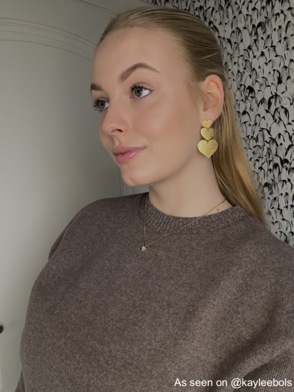 Influencer draagt gouden hartjes oorbellen