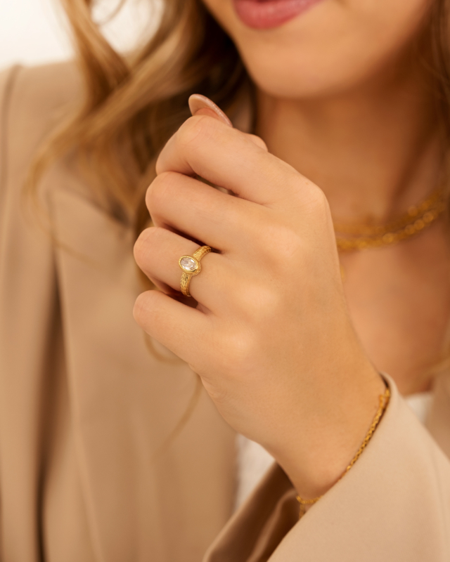 Model draagt gouden ring met steen