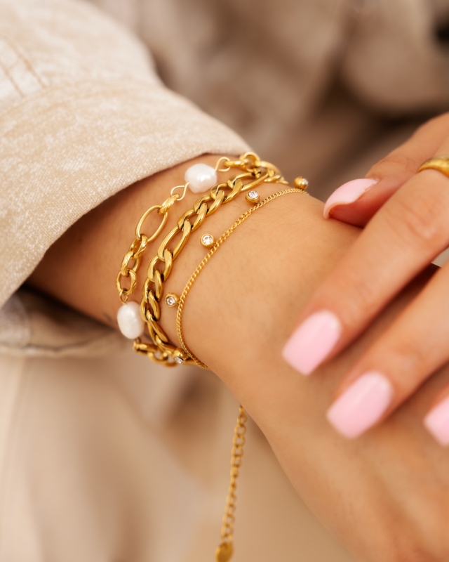 gouden armparty om pols 