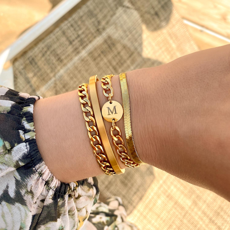 Chunky armparty met initials om de pols voor een trendy look