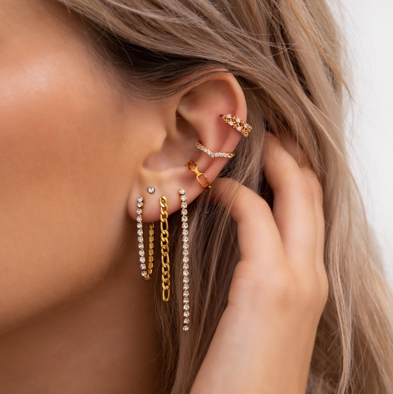 Gouden earparty in het oor van het model