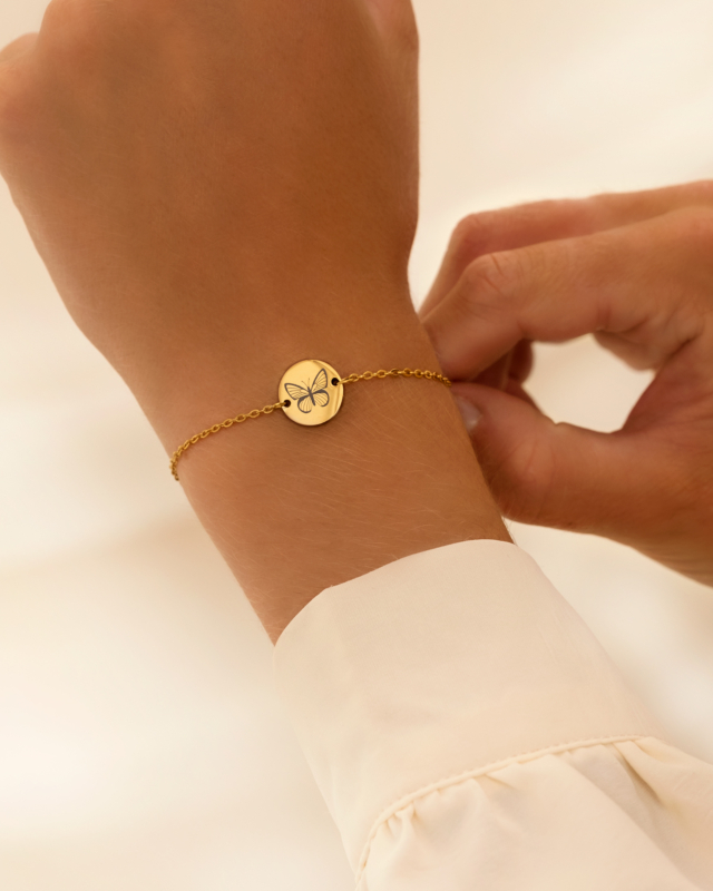 Birth month butterfly armband goudkleurig om pols van model