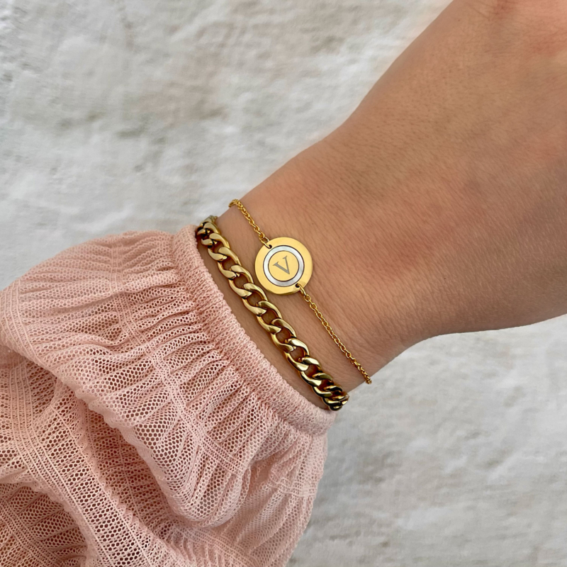 Initial armband met parelmoer om de pols