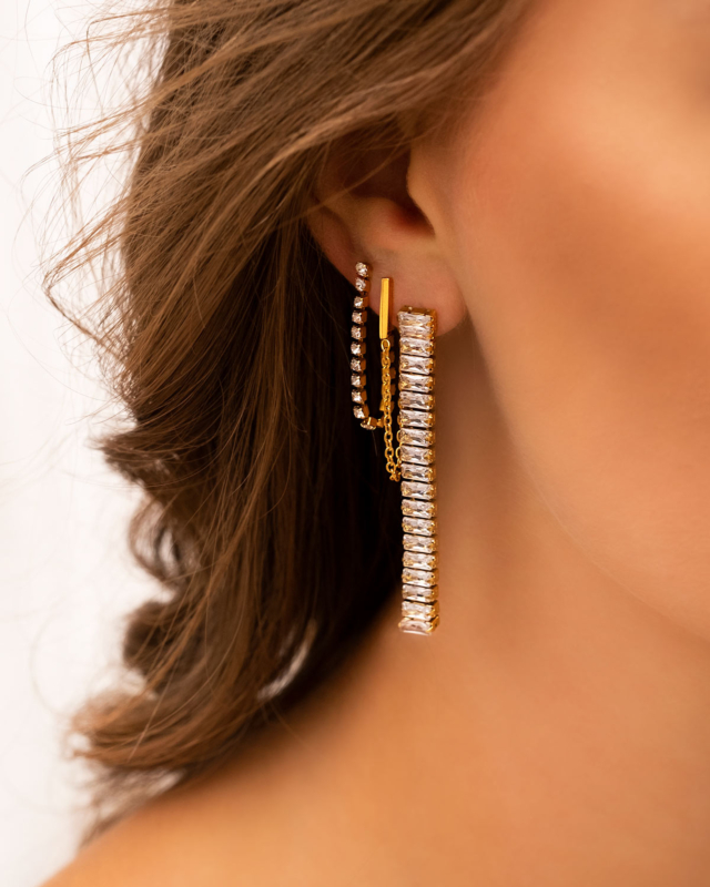 Model draagt gouden oorbellen mix