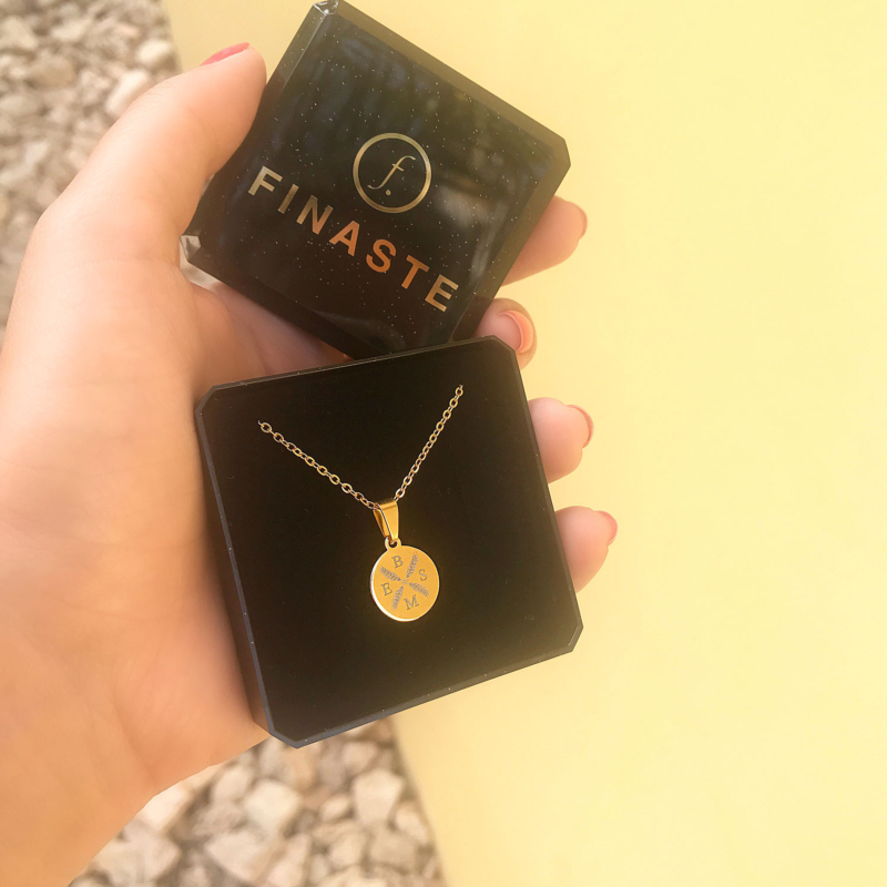 gouden letter ketting in een sieradendoosje met gele muur