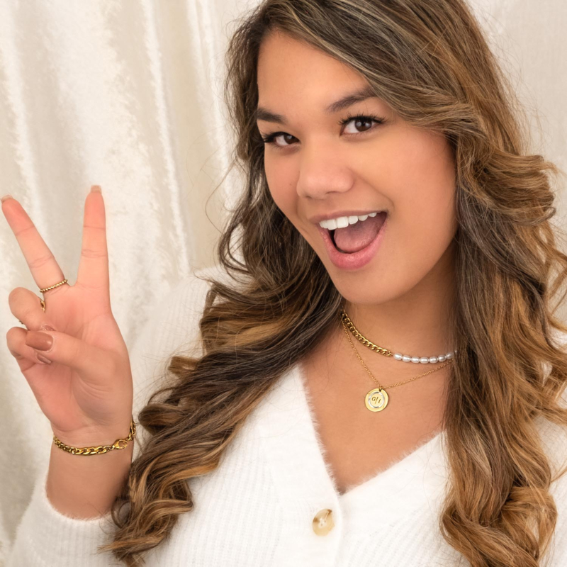 Meisje met een witte trui en gouden sieraden