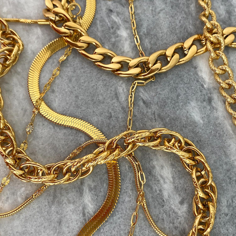 Gouden sieraden op een marmer plaatje voor een complete look