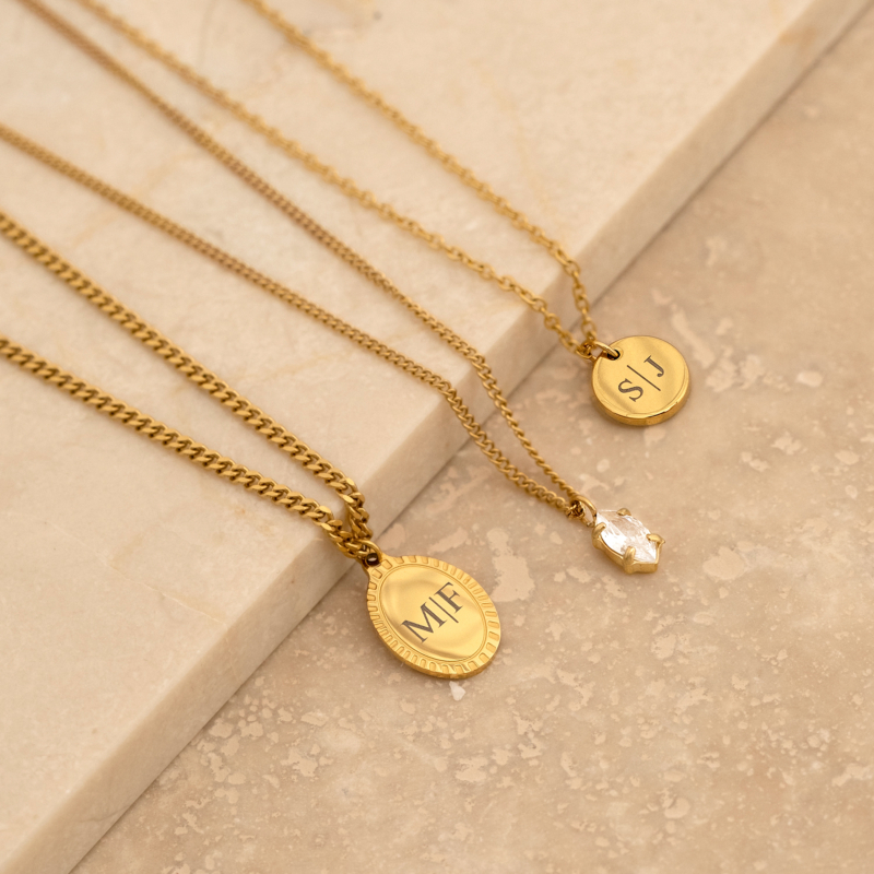 Gouden kettinkjes op marmeren ondergrond