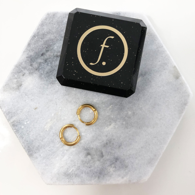 Minimalistische oorringetjes op marmeren plaatje