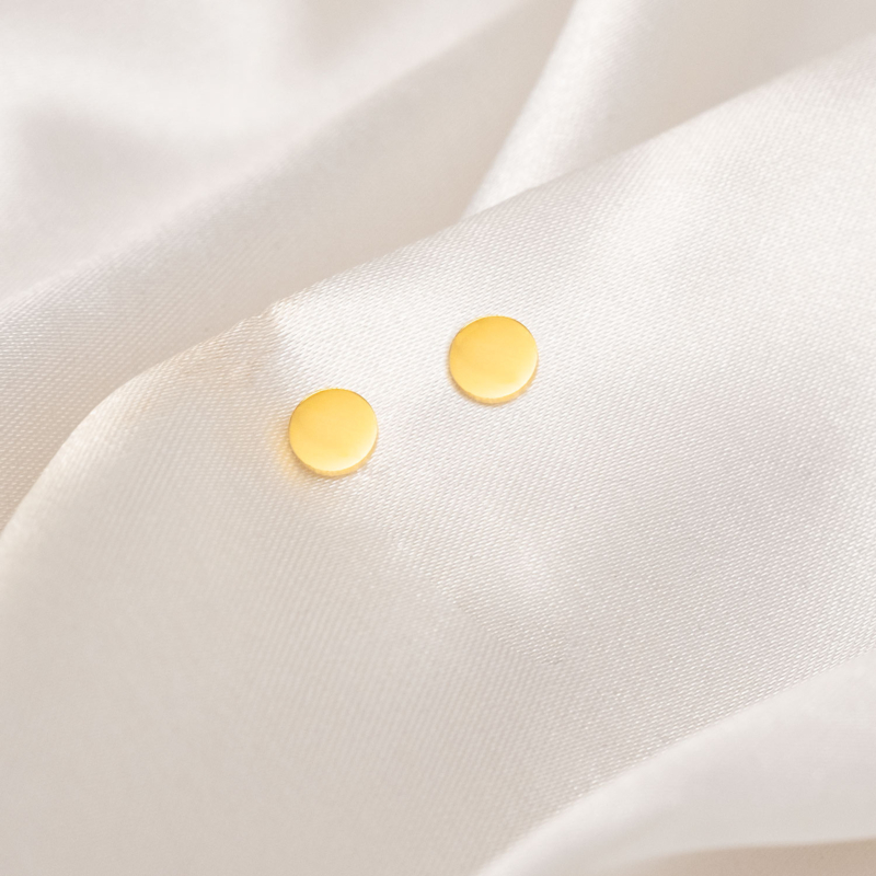 Oorknopje round goudkleurig op wit satijn