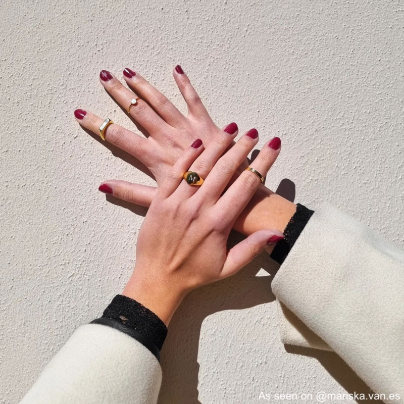 Influencer draagt gouden zegelring met letter