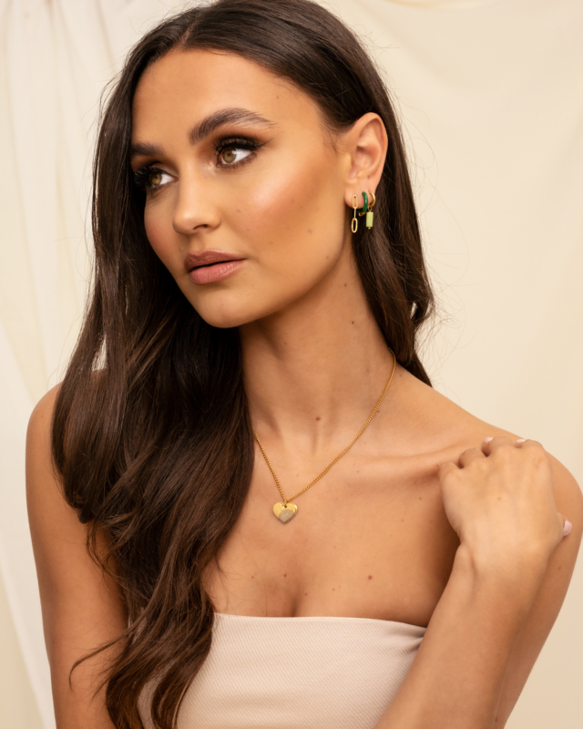 Model draagt gouden vingerafdruk ketting