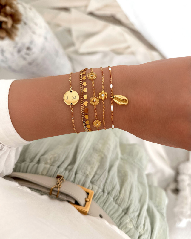 Model draagt gouden armbanden mix