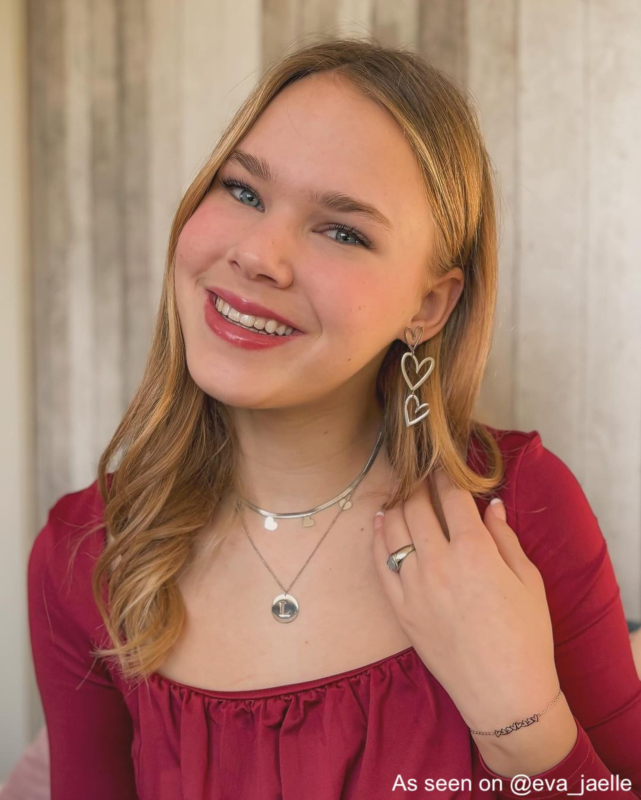 Influencer draagt zilvere ketting met letter