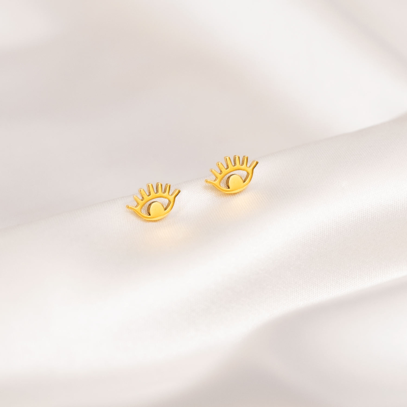 Lucky eye stud oorbellen goudkleurig op wit satijn