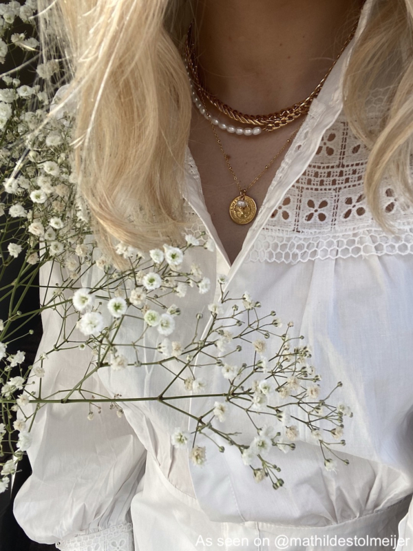 Meisje met gouden finaste kettingen om hals