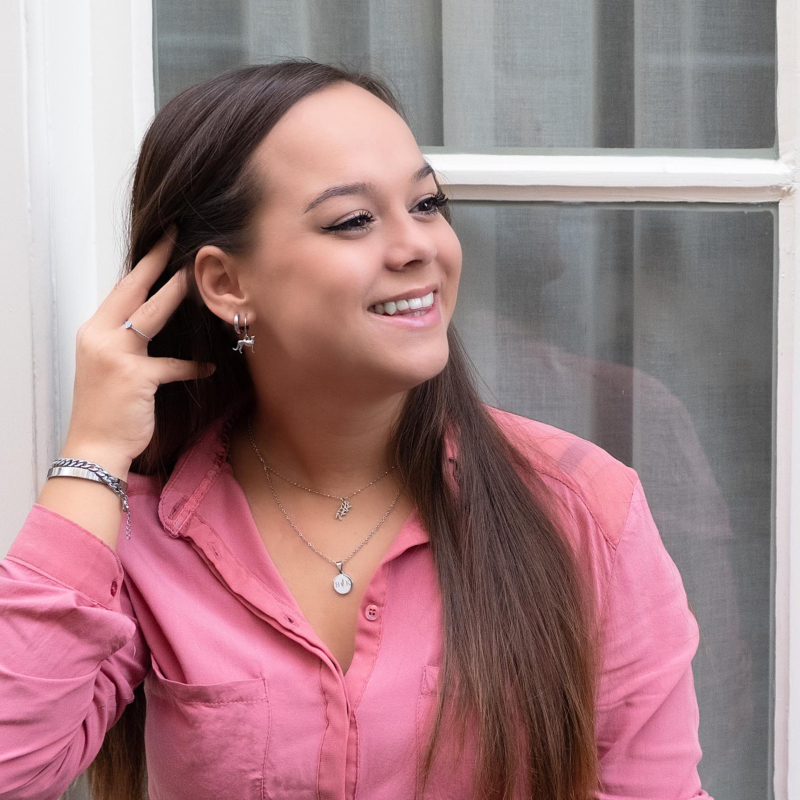 Vrouw draagt een roze top met leuke Finaste sieraden
