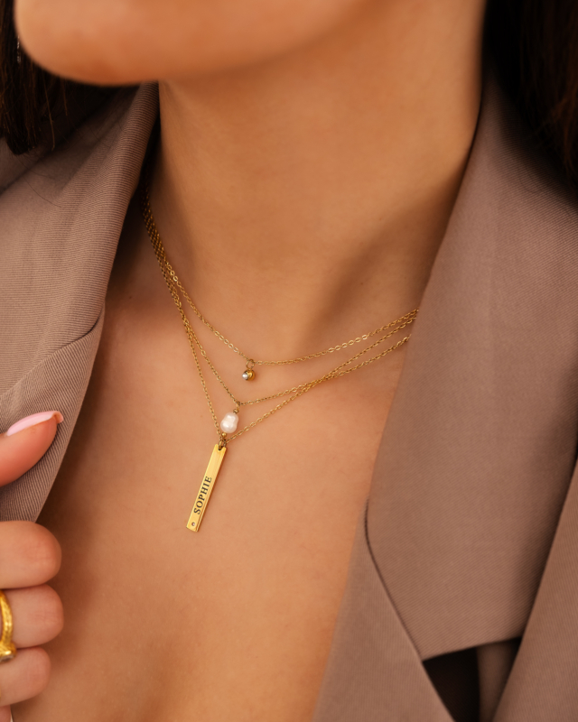 Model draagt gouden kettingen 