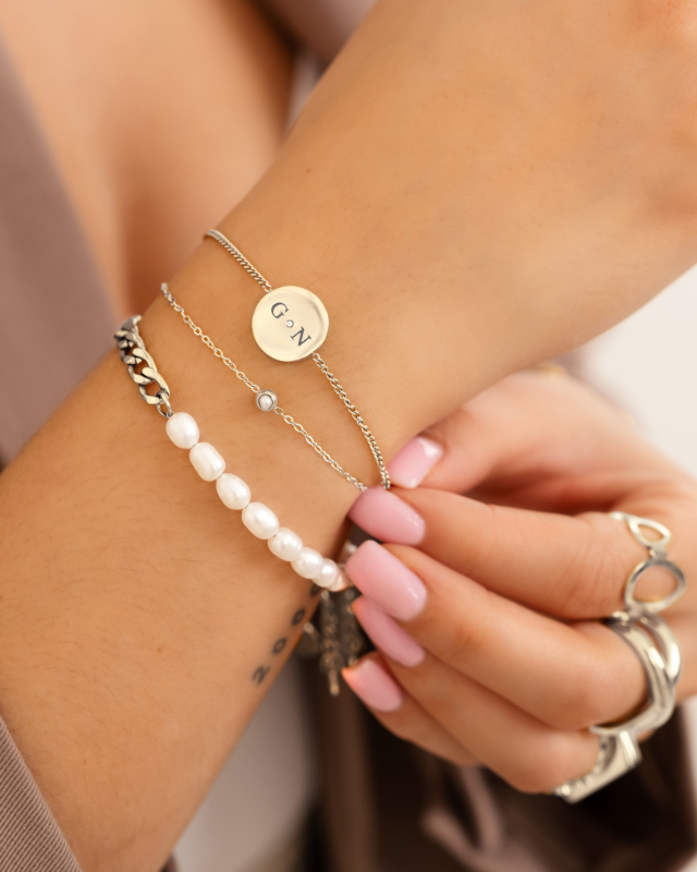 Model draagt zilveren armbanden om pols