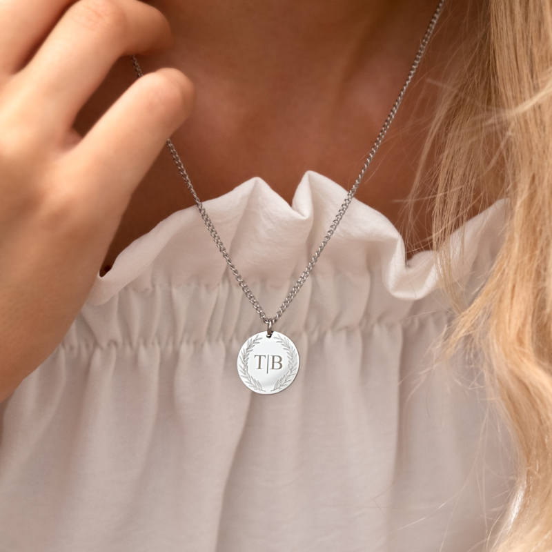 zilveren ketting met persoonlijke munt om hals