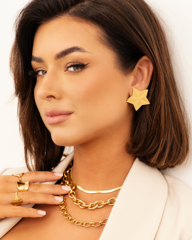 Model draagt gouden ster oorbellen