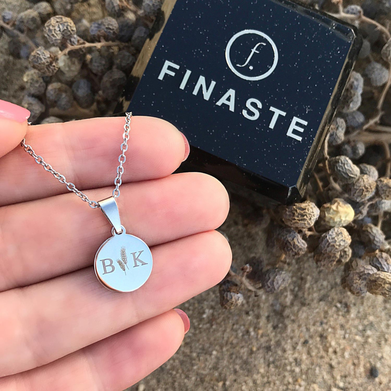 Zilveren letter ketting in de hand met sieradendoosje