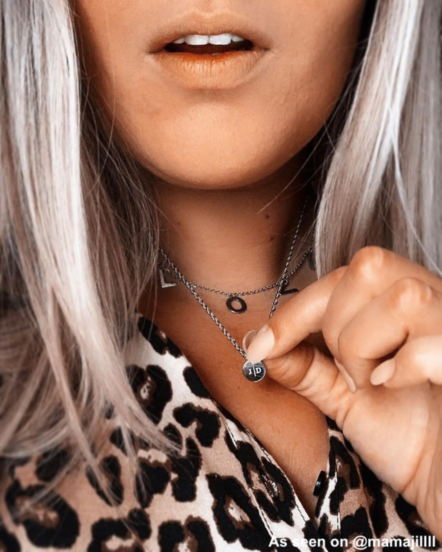 Influencer met zilveren initialen ketting