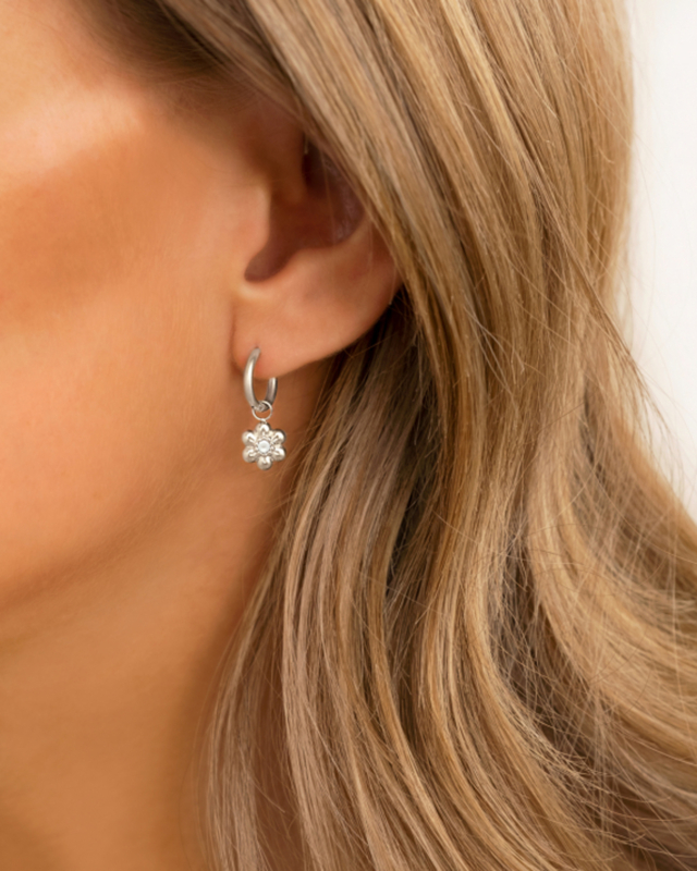 model draagt bloemen oorbel met pareltje