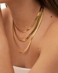 Model draagt gouden kettingen mix