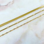 Goudkleurige choker kettingen op marmeren ondergrond