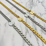 Gouden en zilver initial kettingen op marmeren ondergrond