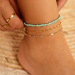 Mix van gouden en blauwe enkelbandjes