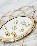 Goud kleurige ear cuffs op een spiegel