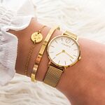 gouden armparty met horloge voor om de pols