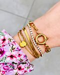 Vrouw draagt goud plat armbandje om pols