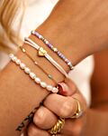 Mix van parelarmband en gouden armbanden